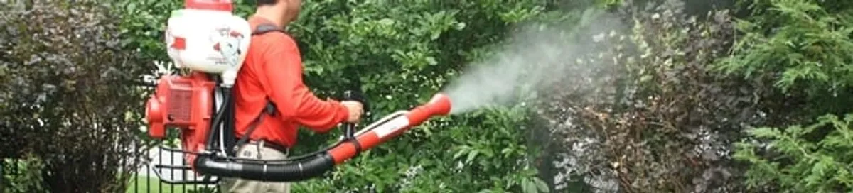 Mosquito control technician fogging shrubs and landscaping for mosquito treatment in San Diego, CA