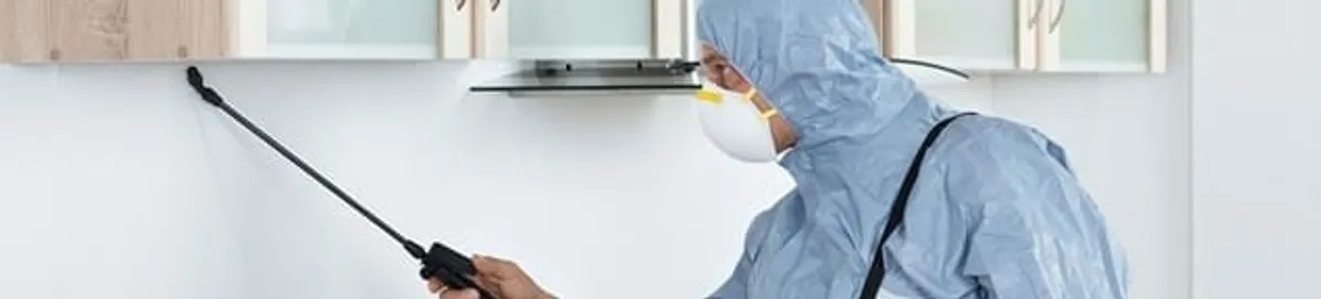 Termite treatment technician applying indoor pest control spray in San Diego, CA